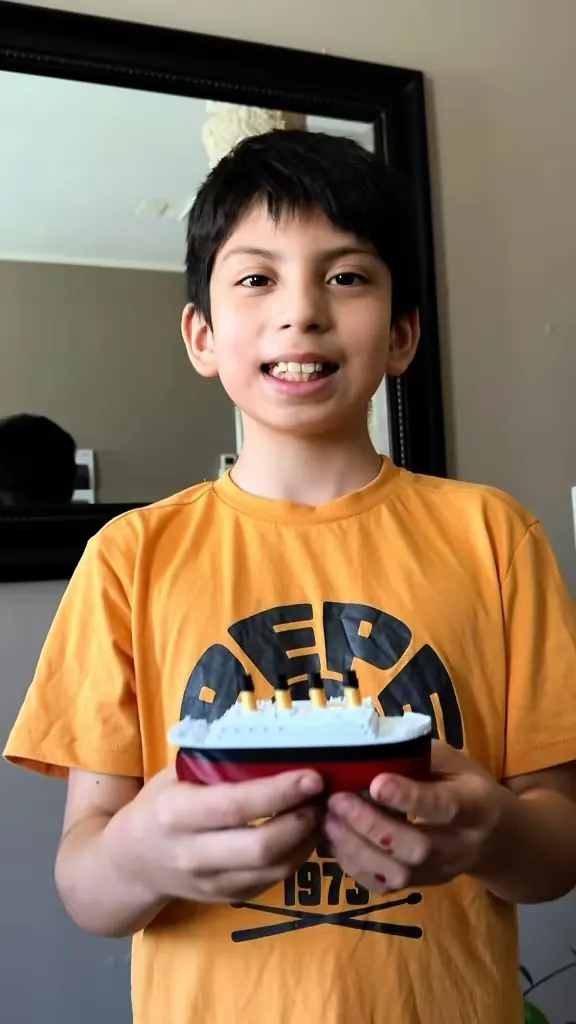 Maxi, el creador de MaxiMaker, sonriendo con un barco impreso en 3D