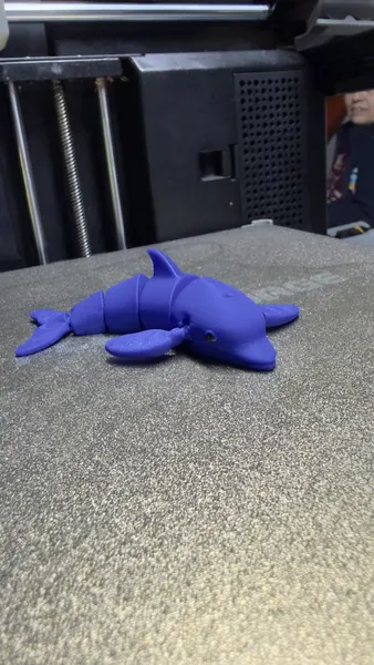 Delfín articulado azul sobre la cama de impresión