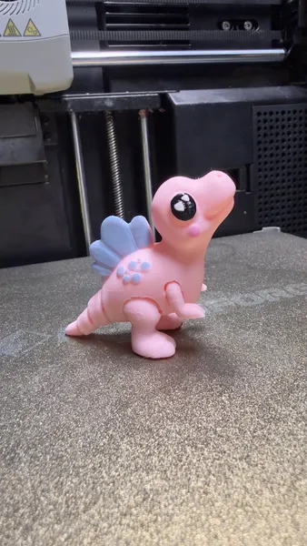 Dinosaurio articulado rosa con vela azul