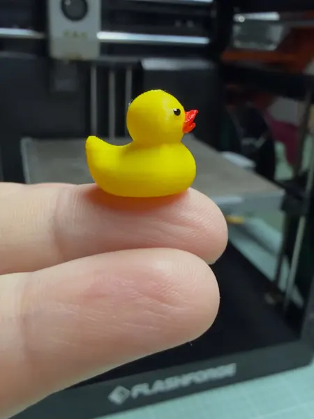 Patito mini sobre un dedo para mostrar el tamaño