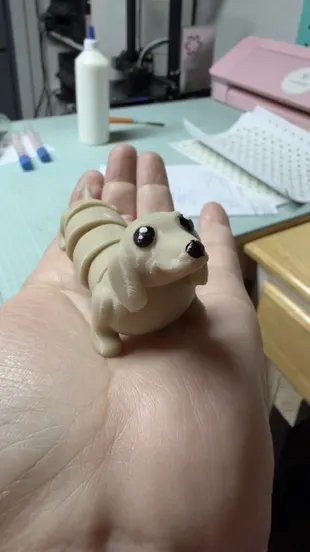 Perro salchicha articulado beige en la mano