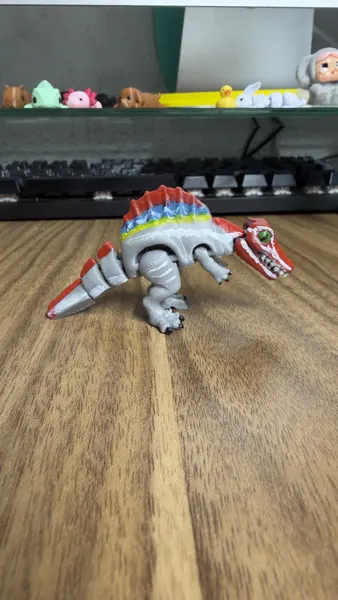 Dinosaurio Spinosaurus articulado gris con vela de colores